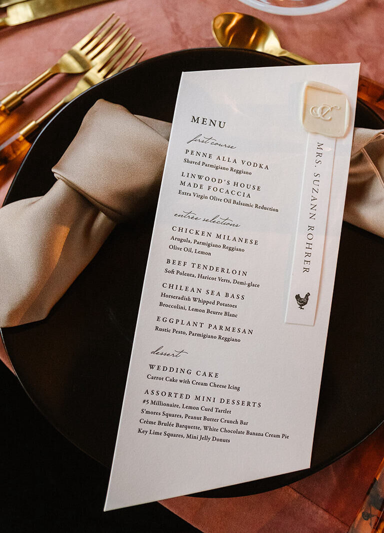 The menu at this industrial wedding featured sharply angled edges, a wax seal boasting the couple's monogram, and a notation of each guest's meal selection.