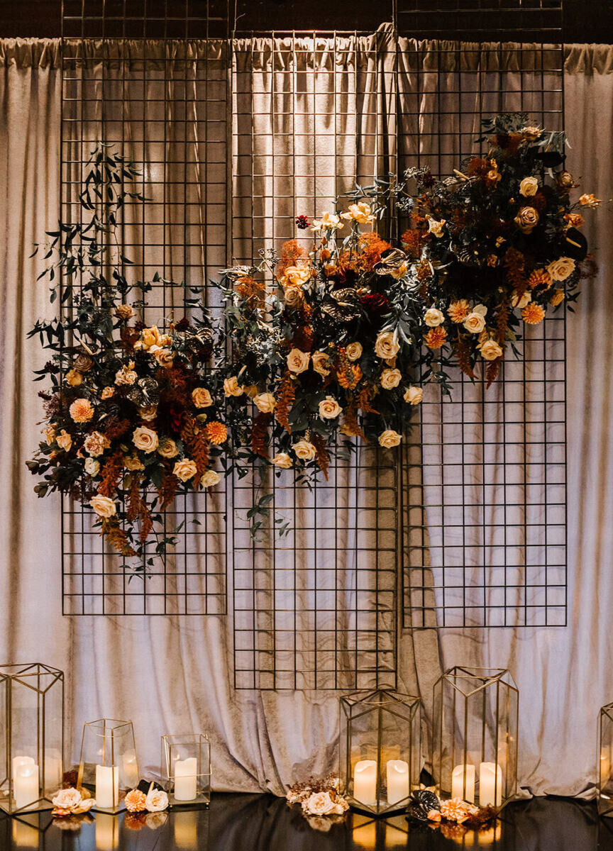 An asymmetrical floral installation on a grid in front of panels of drapery played into the industrial wedding theme.