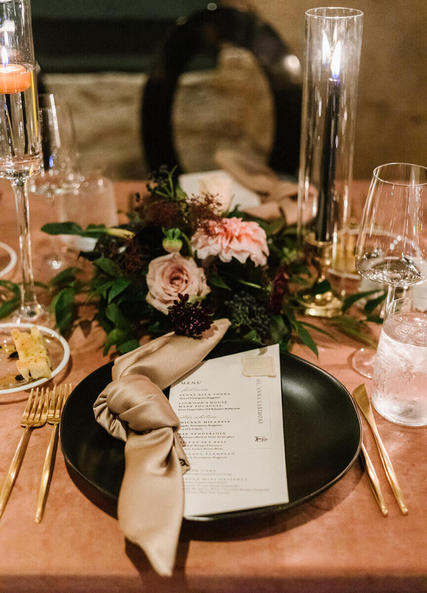 At other place settings for this industrial wedding, knotted taupe napkins rested on modern black plates.