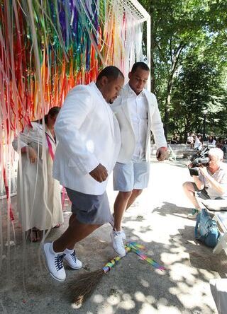 Jump the Broom: Wedding couple participating in the jumping the broom wedding tradition