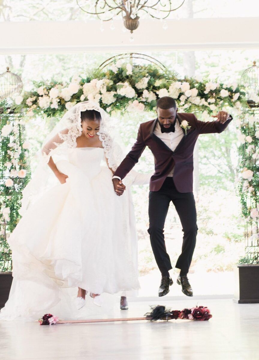 Jump the Broom: Wedding couple participating in the jumping the broom wedding tradition