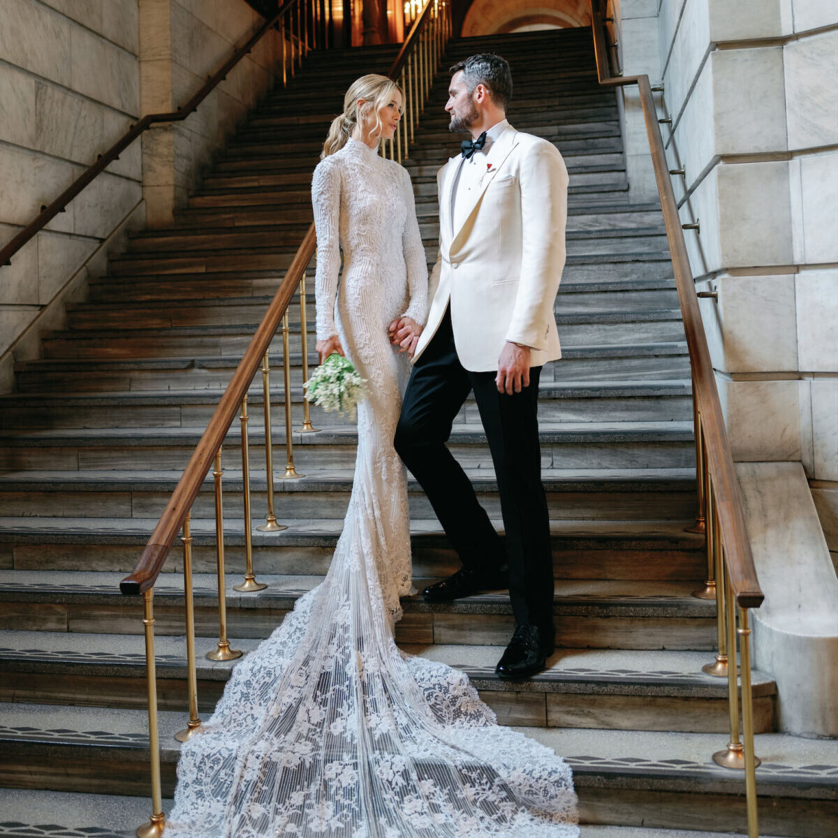 Kate Bock Kevin Love Wedding: Kate Bock and Kevin Love looking at each other on a staircase at The New York Public Library in New York City.