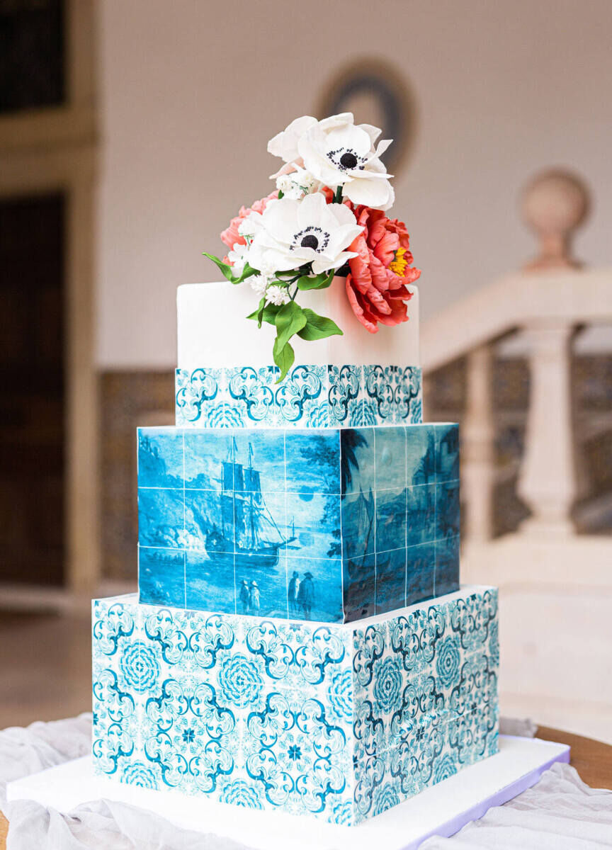 Latinx Heritage: A three-tiered blue and white wedding cake topped with white and pink flowers.