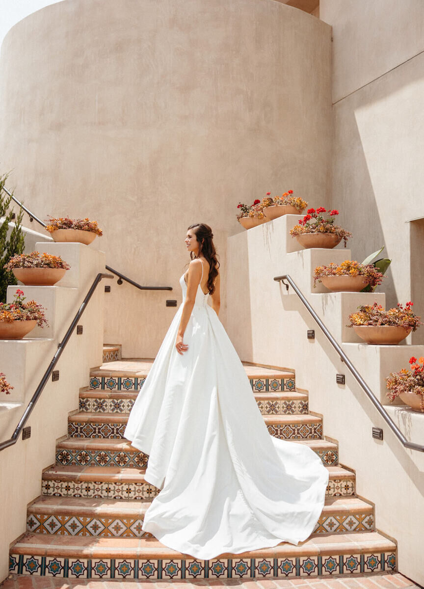 Marriott Weddings: A bride smiling for a portrait on the steps of a staircase at a Spanish style property.