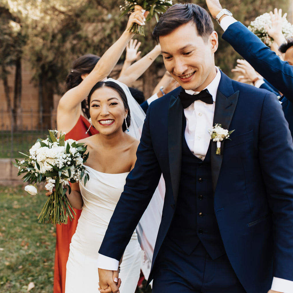 Marriott Weddings: A wedding couple smiling and holding hands after their ceremony in Santa Fe.