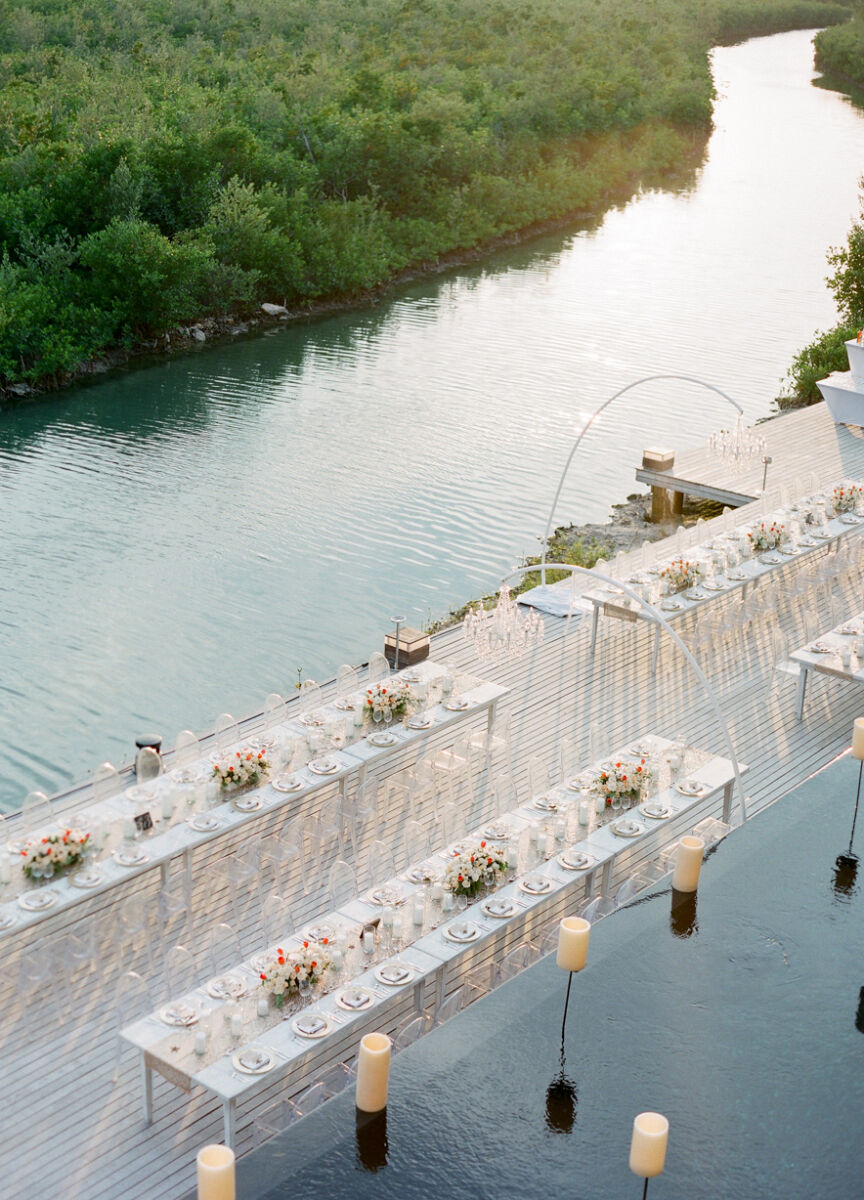 Mexican wedding: aerial shot of long tables on a dock overlooking a jungle-lined waterway