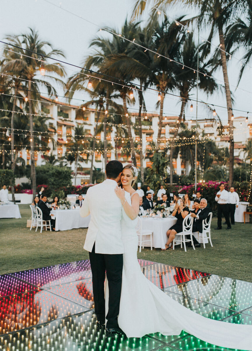 Mexican wedding: couple dancing on their led rainbow lit dance floor at their outdoor wedding reception 