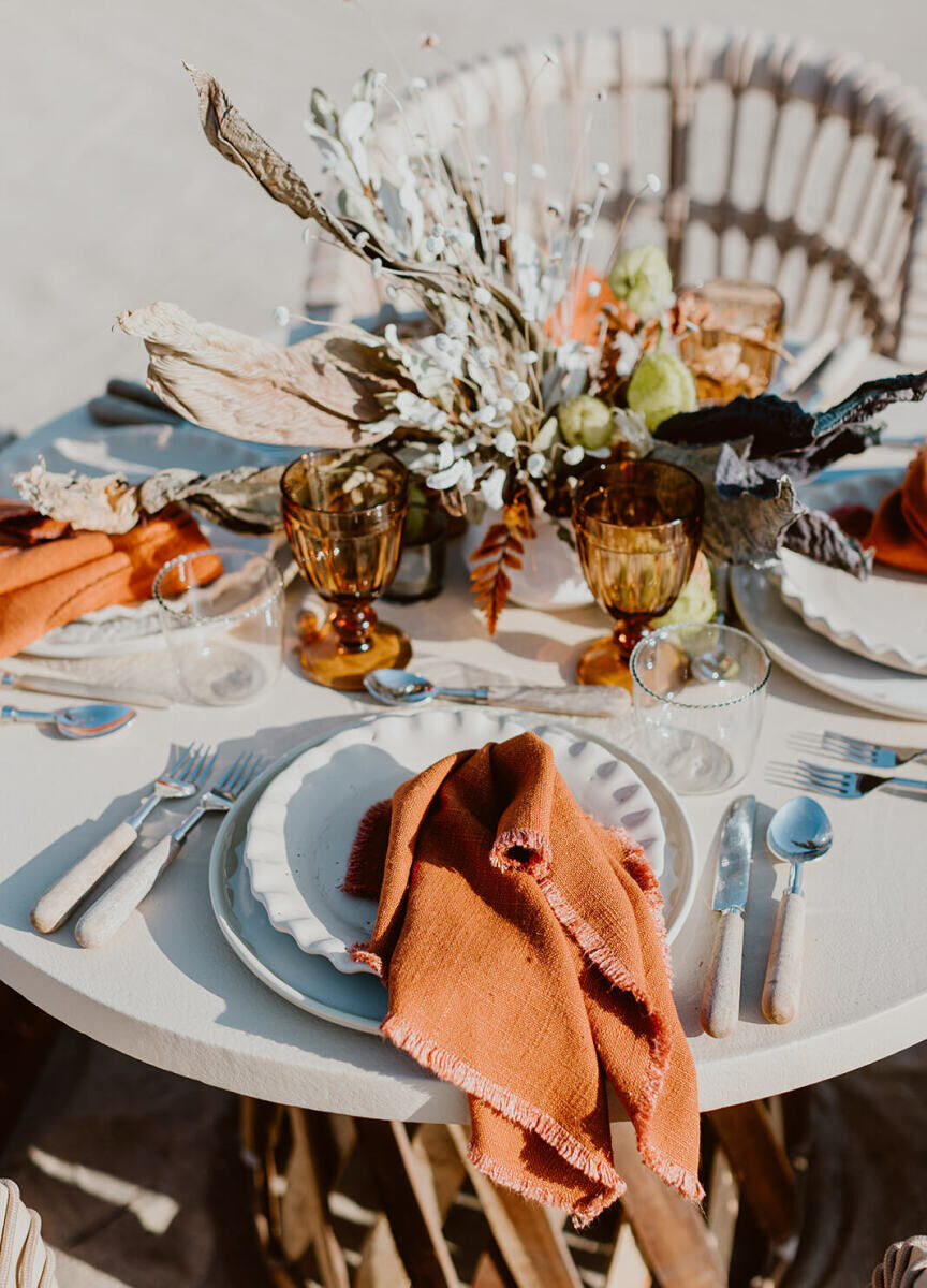 Mexican wedding: an orange wedding table with loose flower arrangement