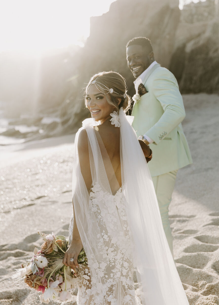 Mexican wedding: couple holding hands walking down the beach at sunset