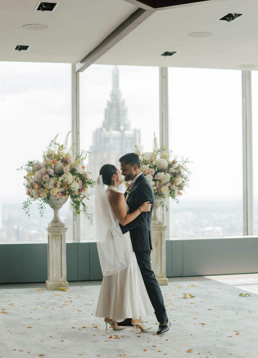 Best Places for a Minimalist Wedding: A bride and groom smiling and holding one another at Manhatta.