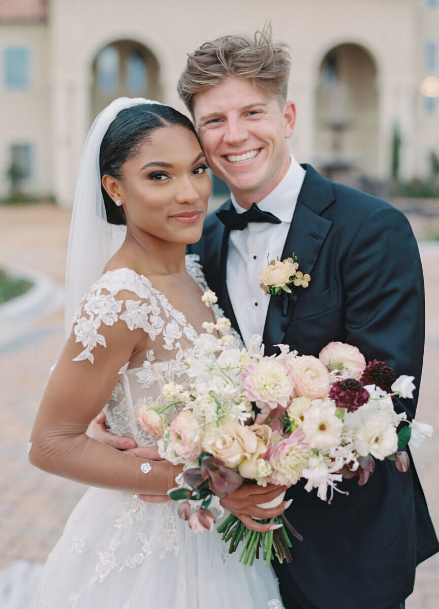 Tara Davis (wearing a Galia Lahav floral-embellished dress) and Hunter Woodhall (in a classic tuxedo) take a portrait at their modern fairytale wedding in McKinney, Texas.