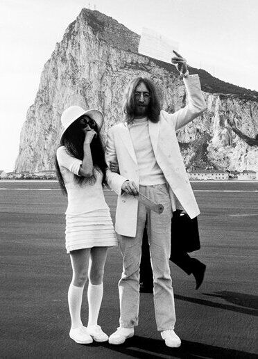 Most Influential Women in History Weddings: Yoko Ono posing on the beach with husband John Lennon