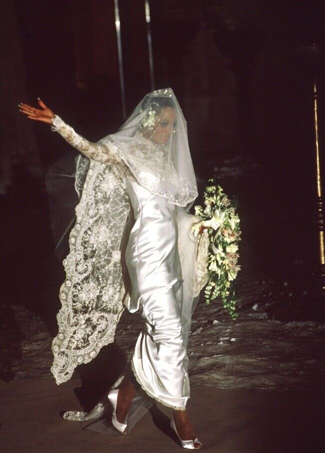 Most Influential Women in History Weddings: Diana Ross walking and waving in a white wedding gown and lace veil