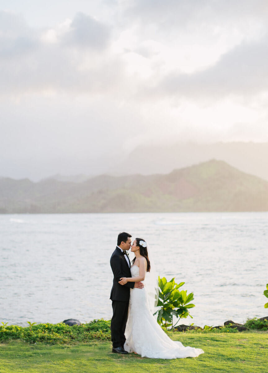 Mountain Wedding: A bride and groom leaning in to one another's faces and holding each other with mountains in the background in Hawaii.