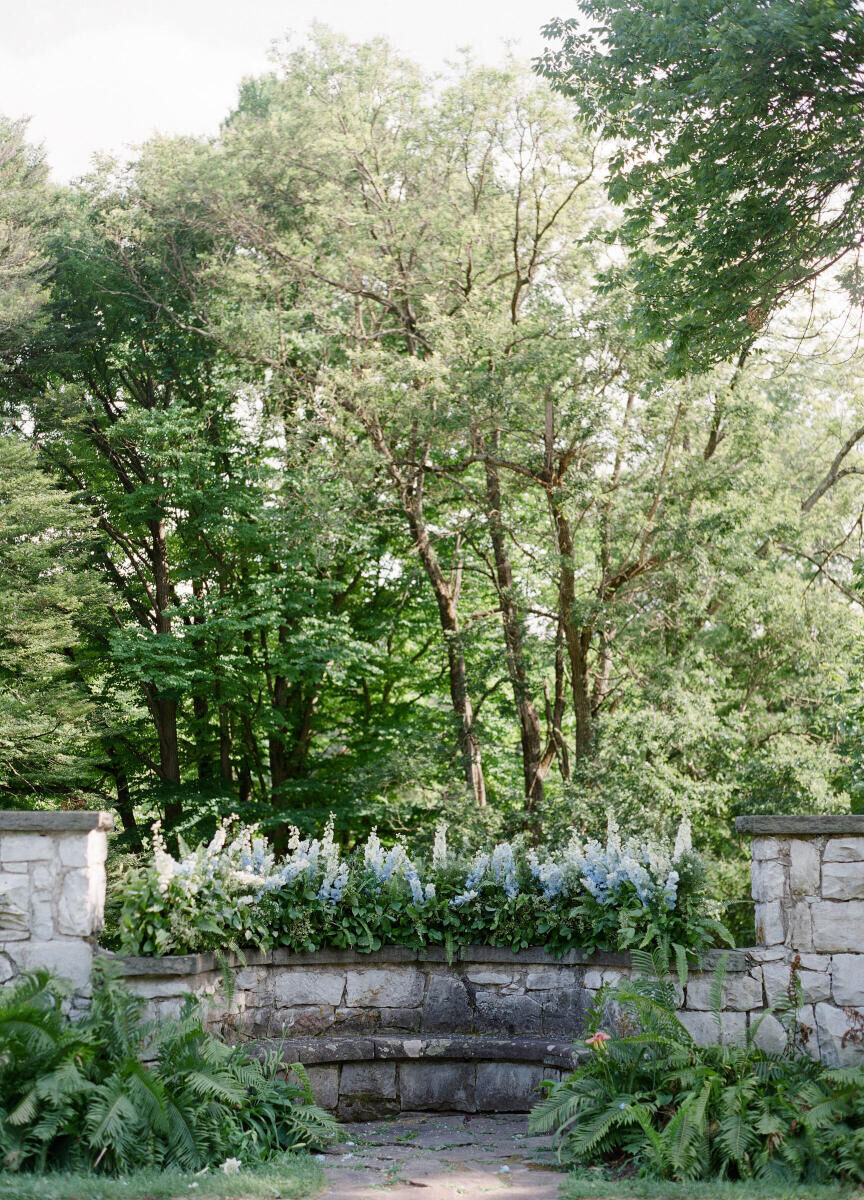 Mountain Wedding: Blue floral arrangements on a rock ledge in the forest of New York.