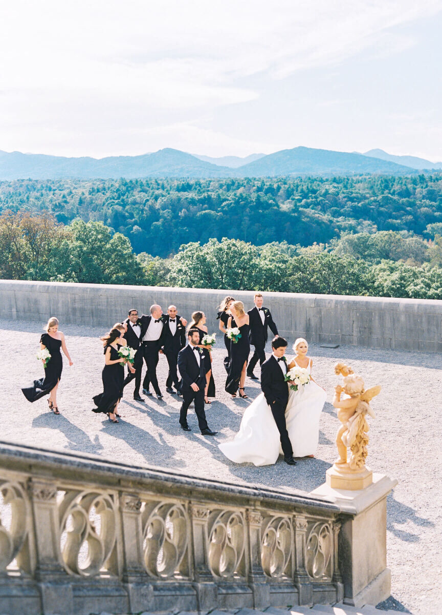 Mountain Wedding: A wedding couple walking on a gravel pathway leading up to an estate's staircase in North Carolina, with rolling hills and mountains behind them.