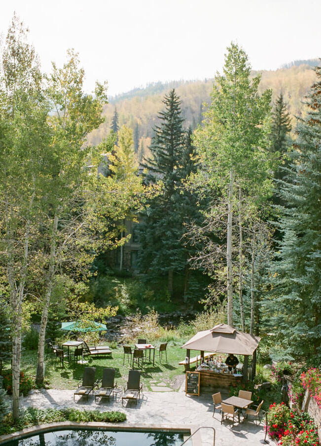 Mountain Wedding: A view of the pool, a pergola, trees and mountains from a hotel in Vail, Colorado.