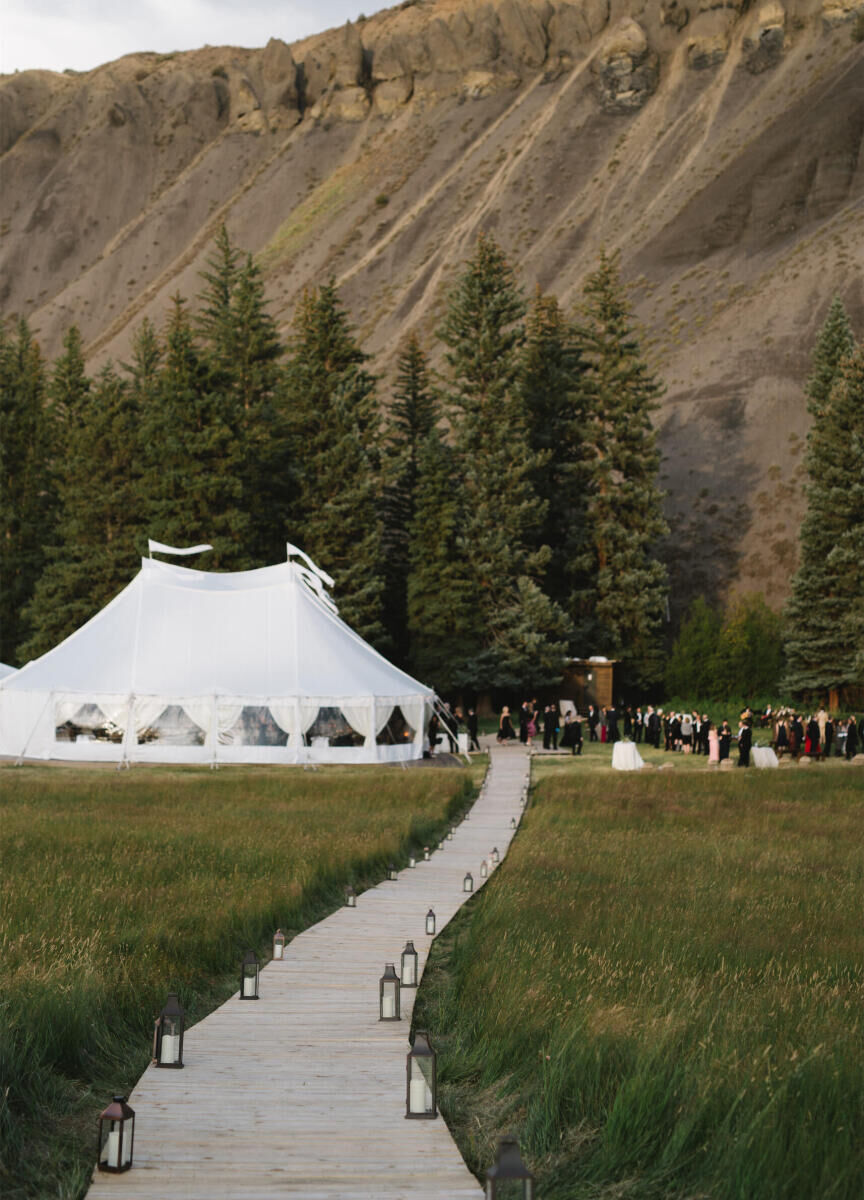 Mountain Wedding: A pathway in a meadow leading up to a white tent at the base of a mountain in Colorado.