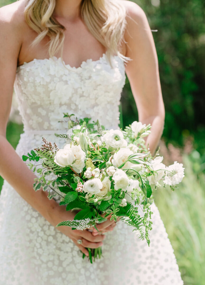 Mountain wedding details: An organically shaped green and white bouquet held by a bride.