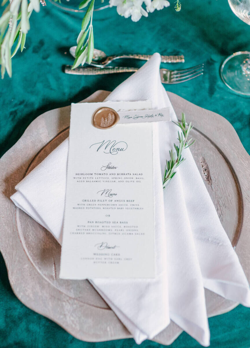 Mountain wedding details: Deckle-edge menus topped with a gold wax seal holding a small place card for a mountain wedding reception in Aspen.