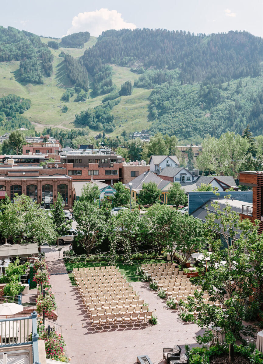 Mountain wedding details: Aerial shot of the courtyard of Hotel Jerome, set for a green-and-white wedding ceremony with views of the mountains in the distance.