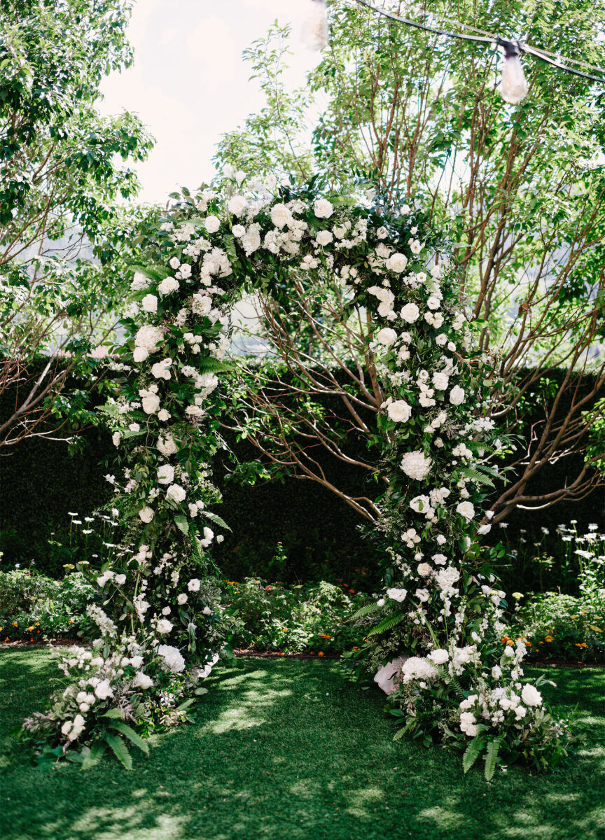 Mountain wedding details: Wedding reception arch, green foliage adorned with white blooms.