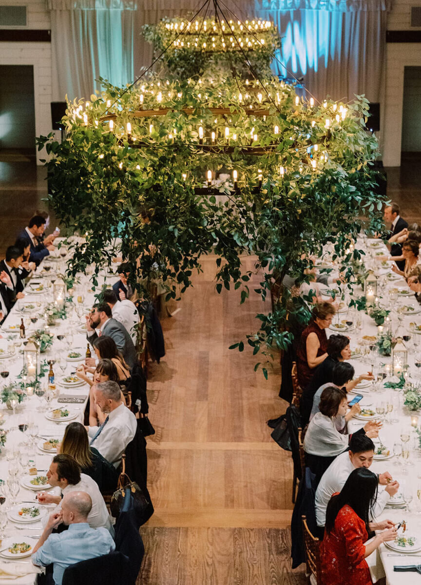 Pippin Hill Farm: An overhead view of two long rectangular tables with an oversized chandelier covered in greenery above.