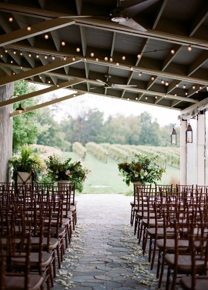 Pippin Hill Farm: An indoor ceremony setup on an enclosed terrace overlooking the vineyard beyond.