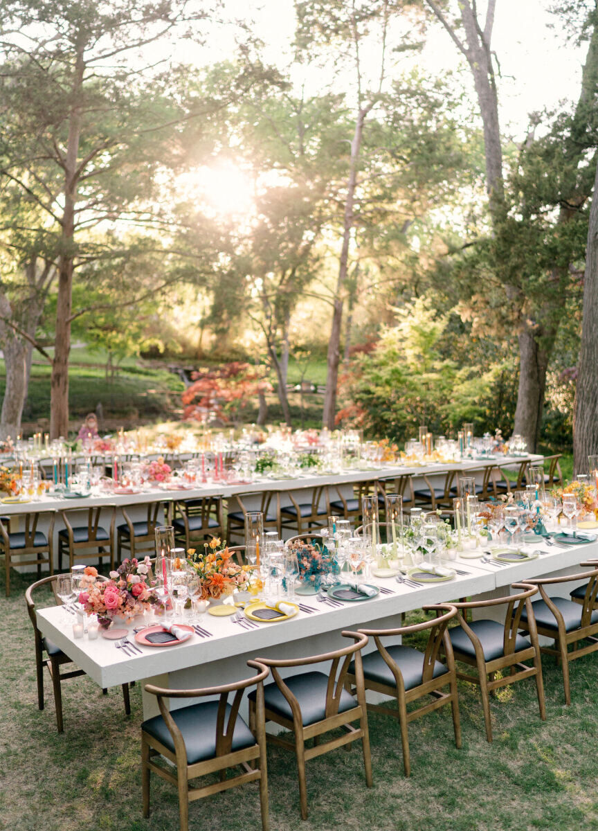 A rainbow wedding reception alternated between color-blocked tables like this all-yellow one, and tables with alternating placesettings in assorted hues.