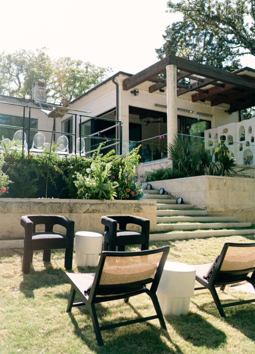 Black and white wedding lounge furniture arranged in the backyard of a matching black and white modern home.