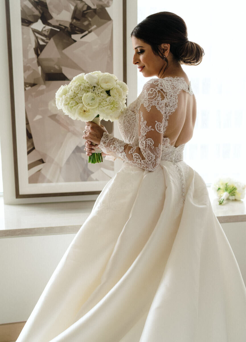 Royal Wedding Dresses: A bride wearing a lace long-sleeve wedding gown while holding a bouquet of flowers.