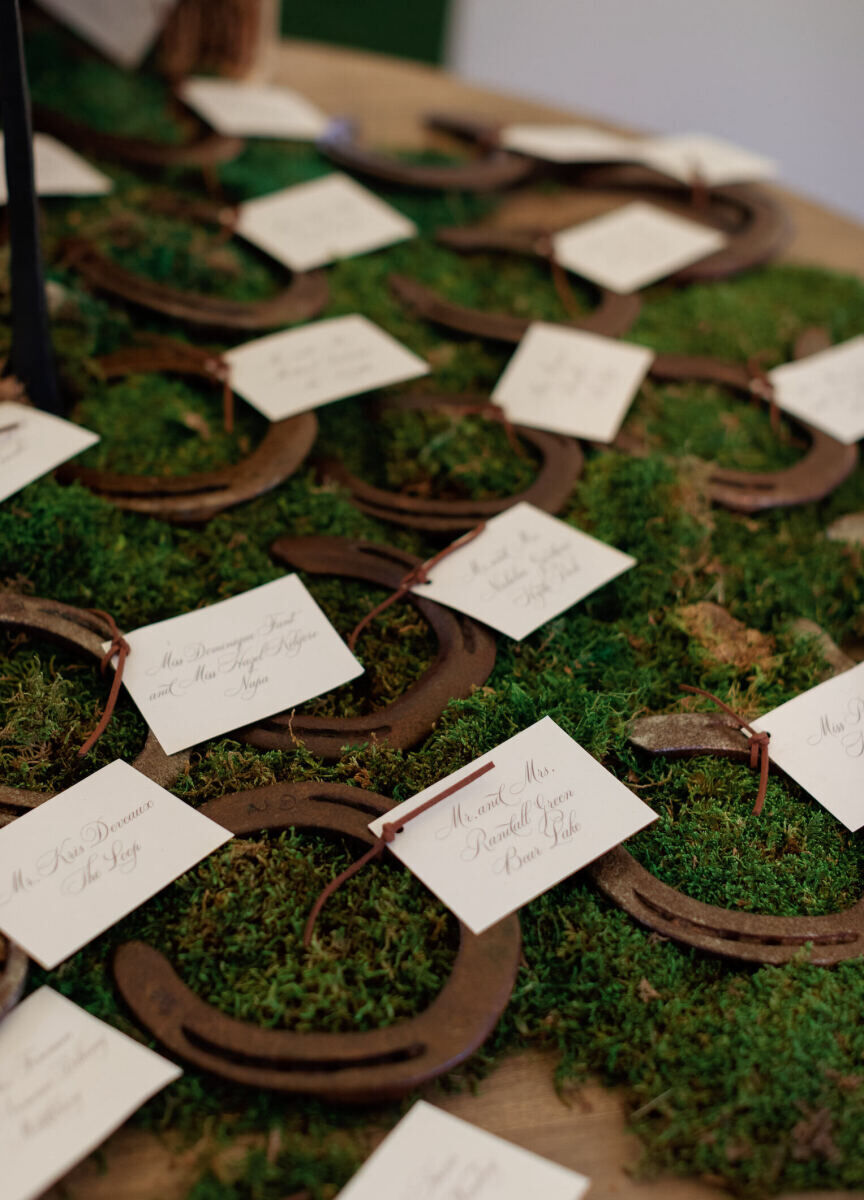 To honor the bride's love of horses, calligraphed escort cards were tied to horseshoes and set out during the reception of her rustic outdoor wedding.