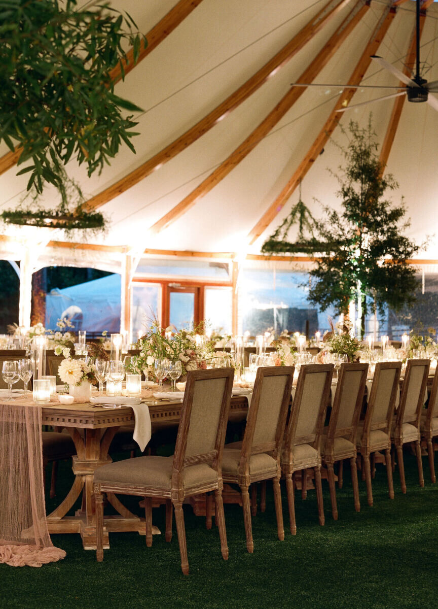 A tented reception space was aglow with uplighting and softened with real trees following a rustic outdoor wedding ceremony.