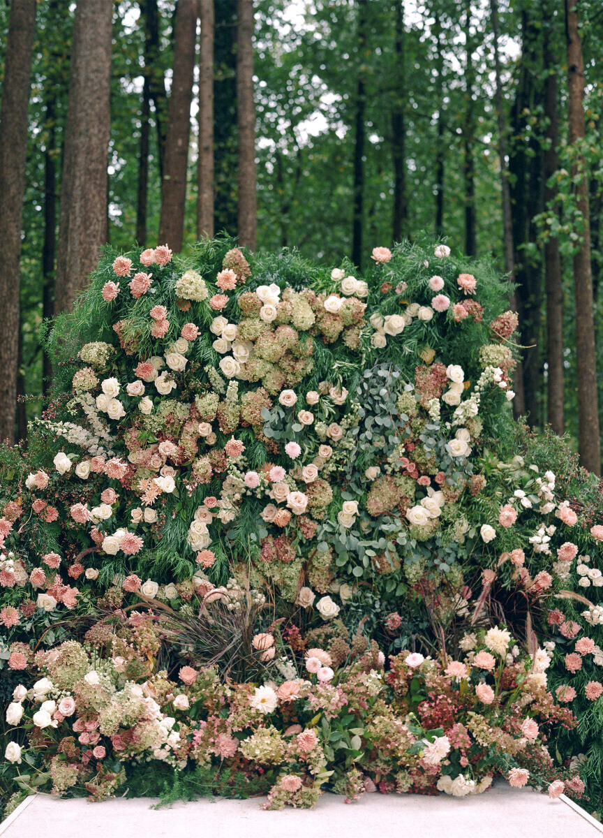 A floral installation anchored the ceremony space of a rustic outdoor wedding in the woods of Virginia.