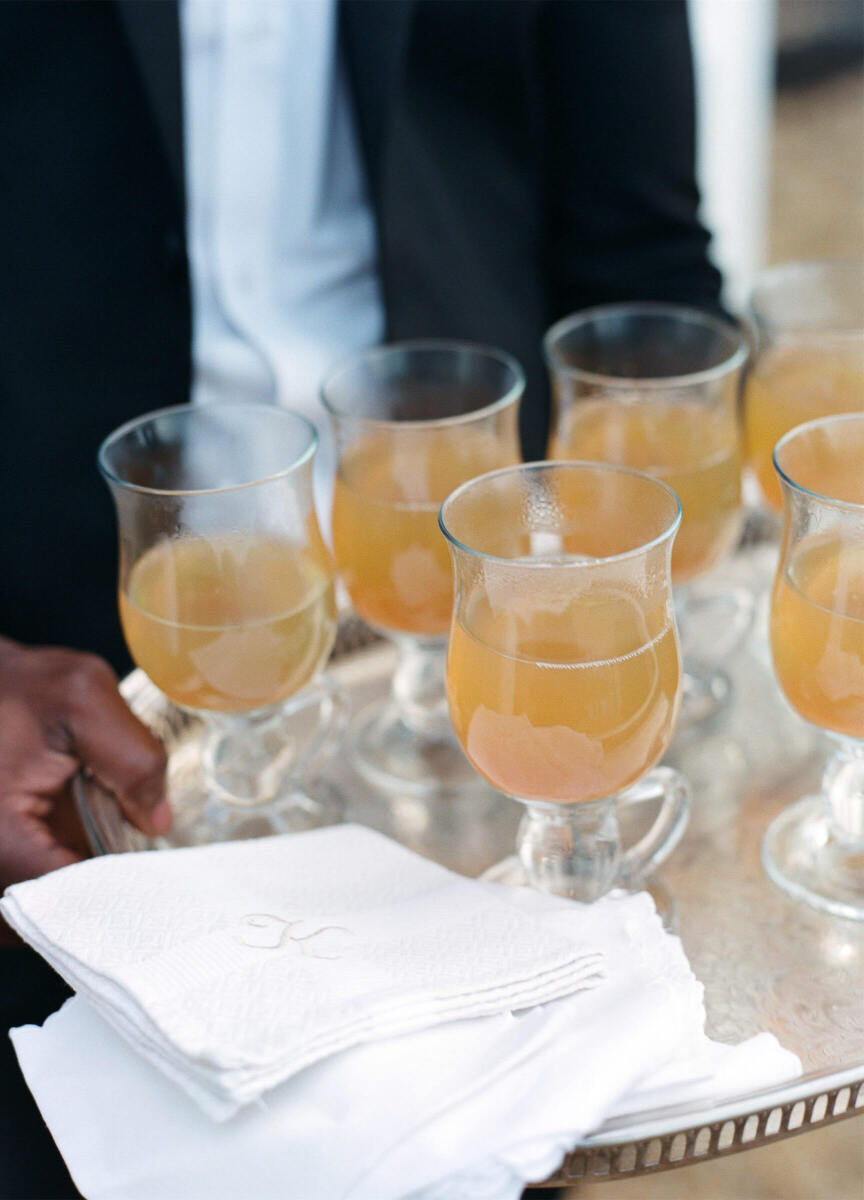 Drinks were passed with monogrammed napkins at a rustic outdoor wedding.