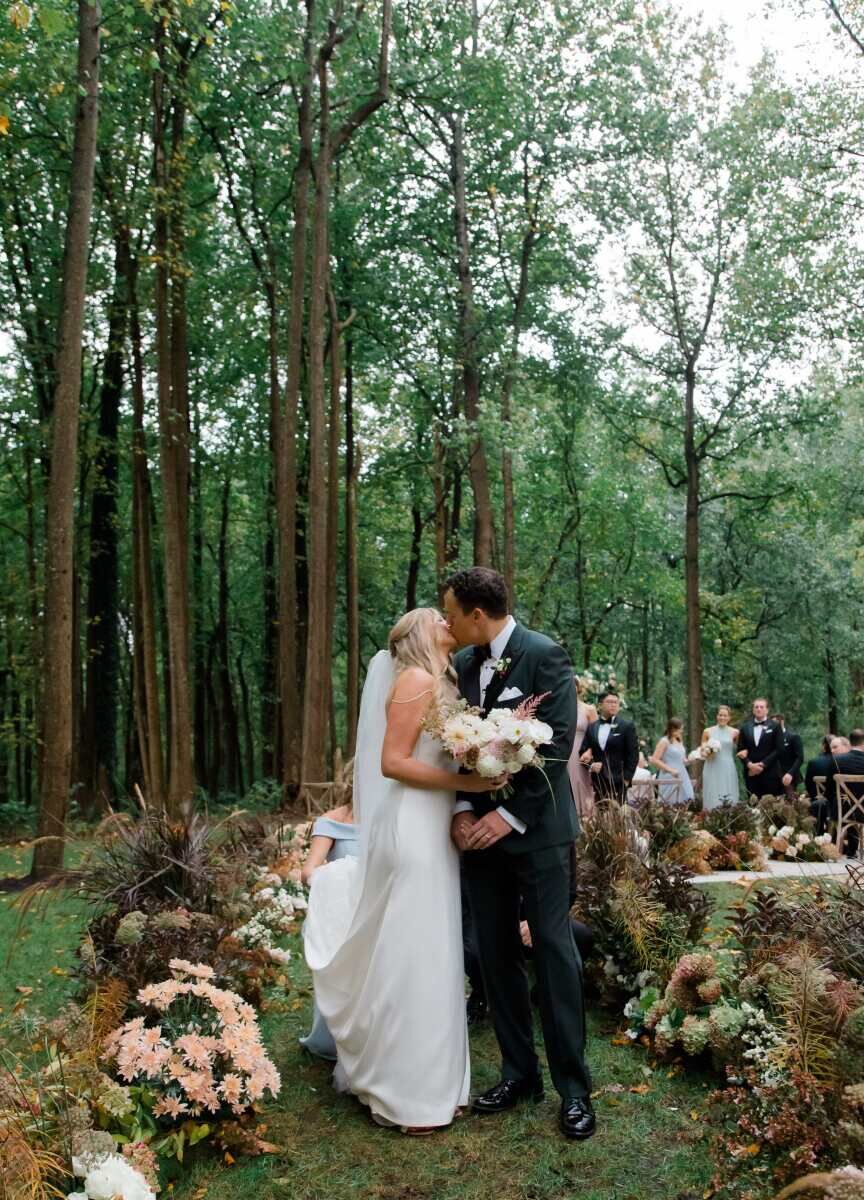 A pair of newlyweds recess up a flower-lined aisle at their rustic outdoor wedding in Virginia.