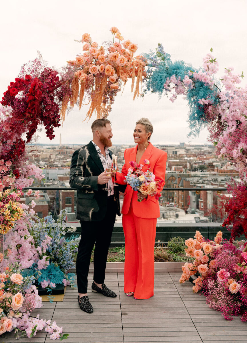 A groom and bride under the floor arch that they used as a lounge backdrop before turning it into a ceremony arch for their surprise wedding.