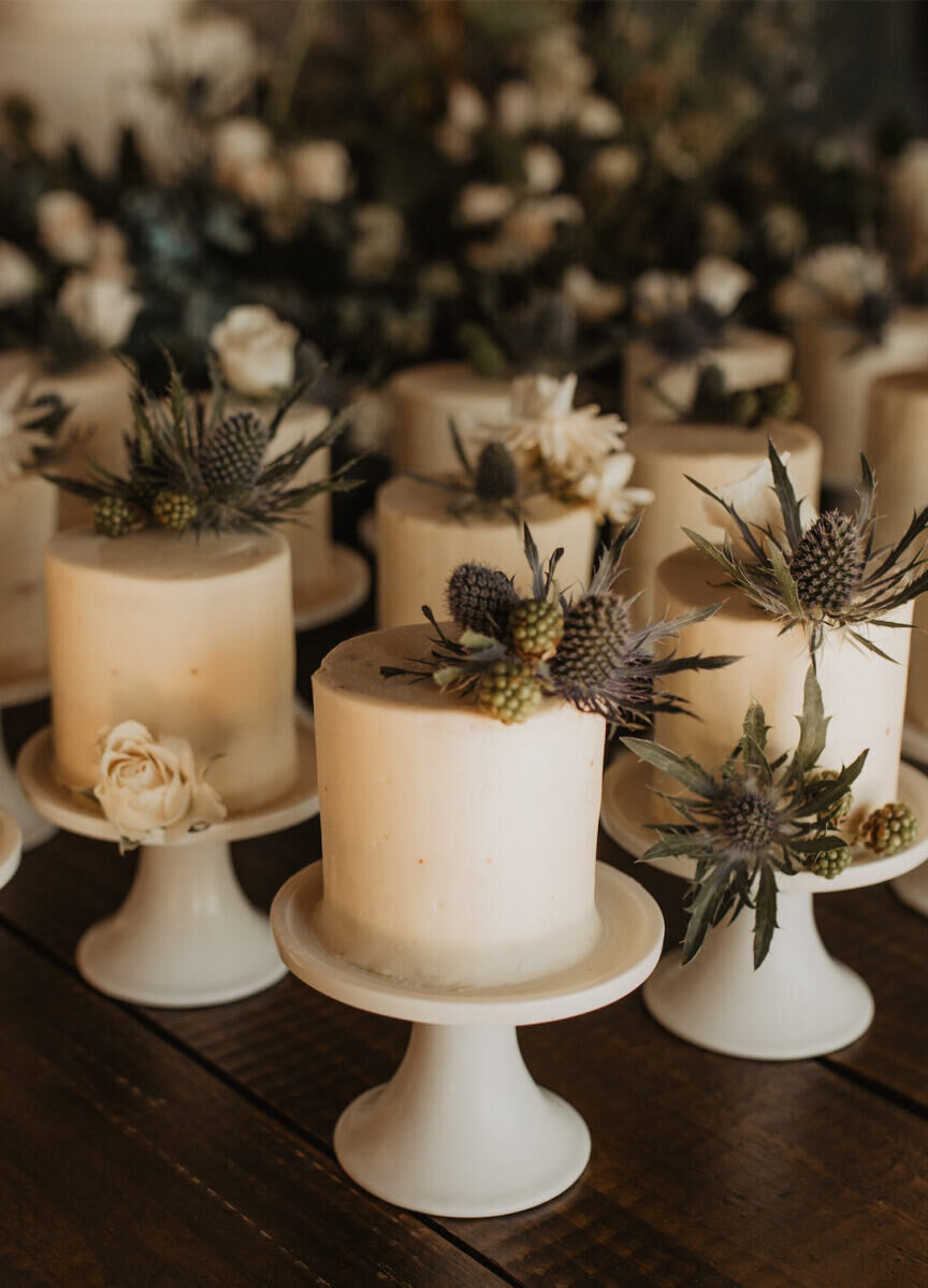 Individual wedding cakes topped with fresh flowers were served to guests instead of sliced wedding cake at this untraditional wedding.