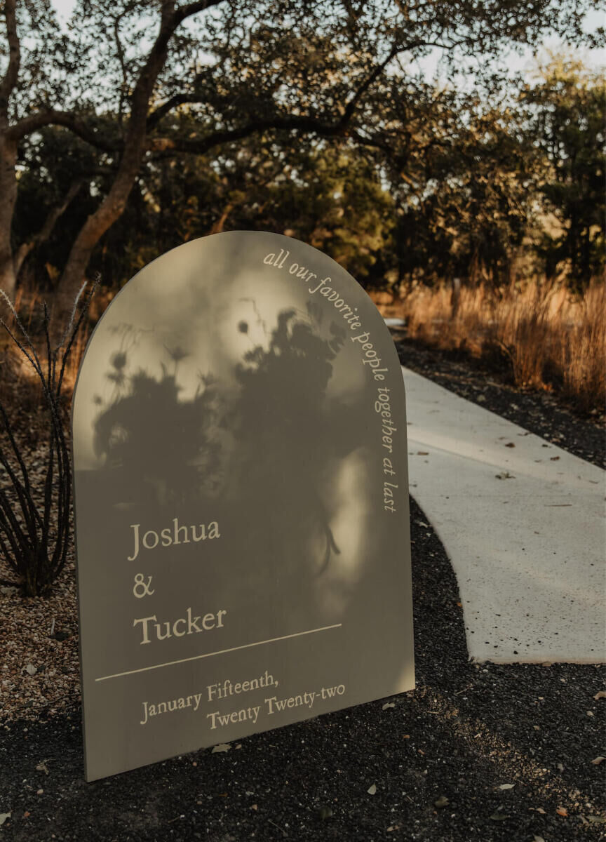 A rounded sign welcomed guests to an untraditional wedding at a ranch in Texas.