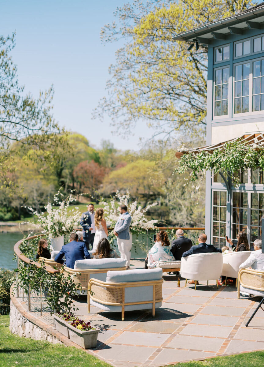 Wedding Aisle: An intimate outdoor ceremony with a couple exchanging vows on a patio while guests look on in oversized, cushioned chairs.