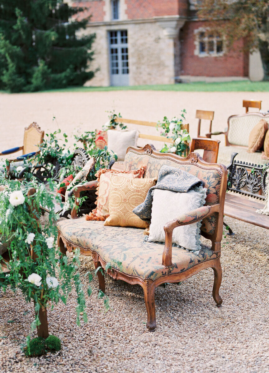 Wedding Aisle: Couches with pillows and mismatched chairs serving as ceremony seating at an outdoor wedding.