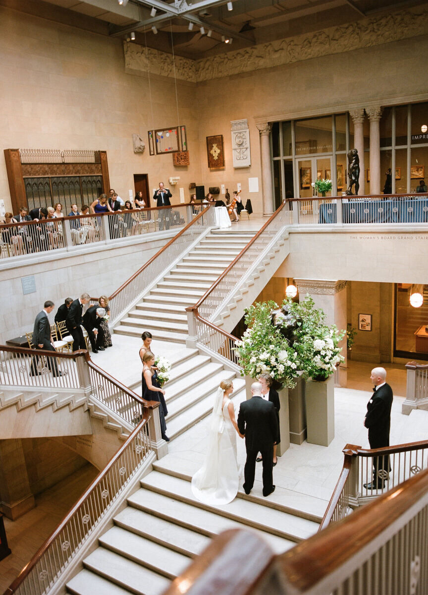 Wedding Aisle: A couple getting married in the center of an elaborate staircase at a museum in Chicago.