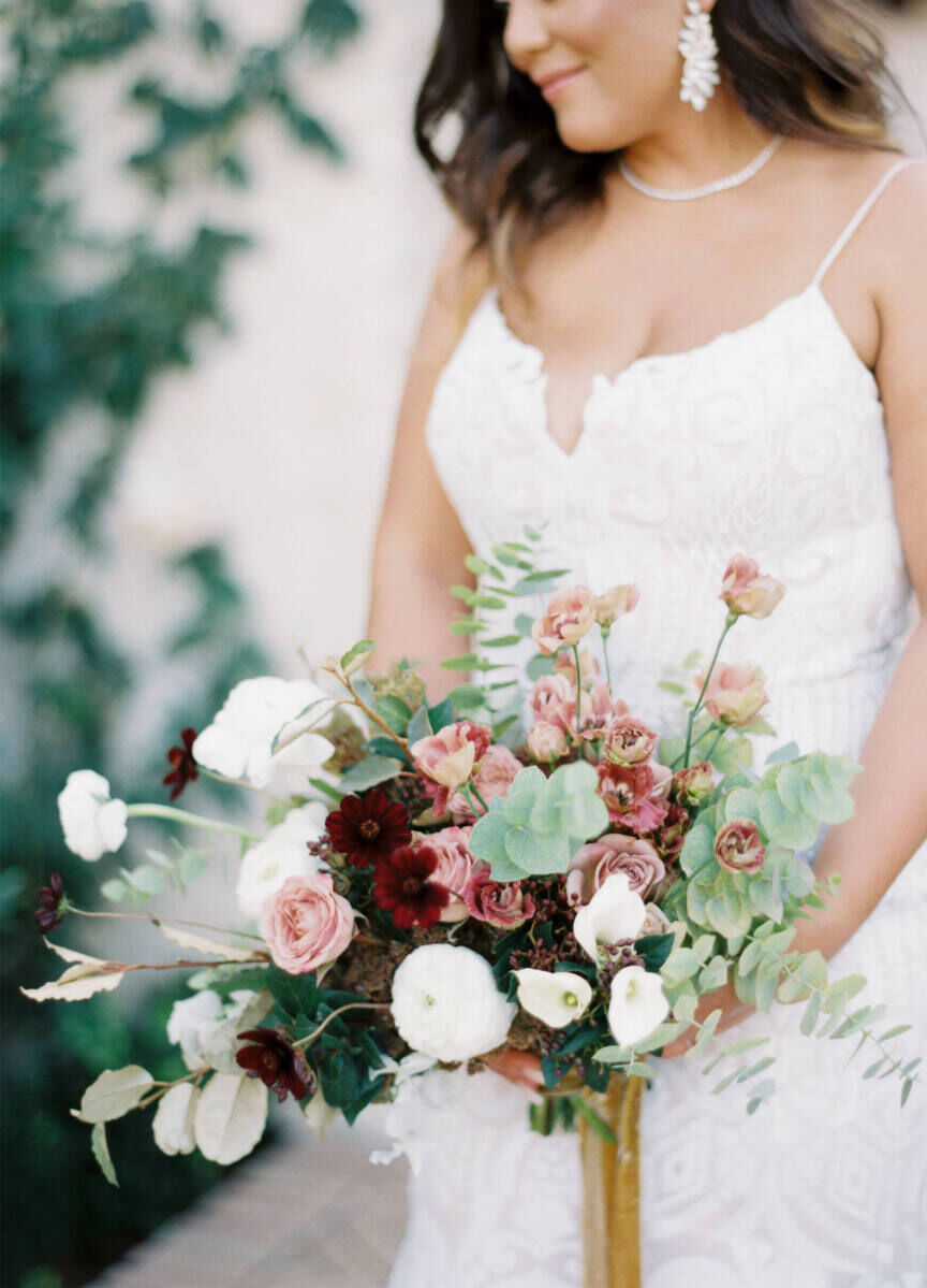 Wedding details: A bridal bouquet in shades of pink, red, and white, with eucalyptus accents.