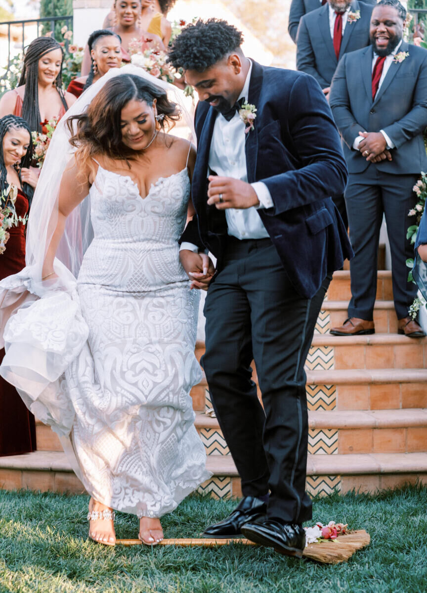 Wedding details: A bride and groom jumping the broom during their wedding ceremony.