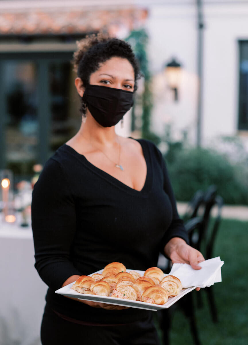 Wedding details: A server holding a tray of appetizers at a wedding cocktail hour.