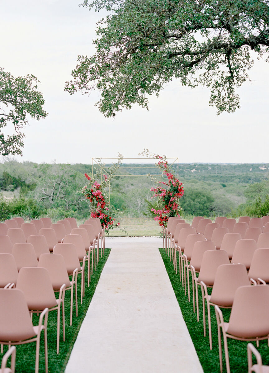 Pink wedding details: Modern pink chairs arranged neatly in front of a modern, bougainvillea-covered ceremony structure.