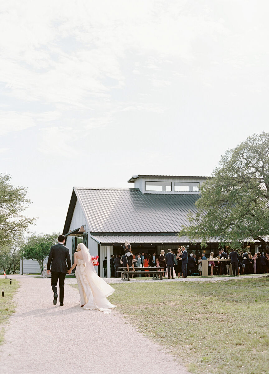 Pink wedding details: A couple entering their modern barn reception in Texas.