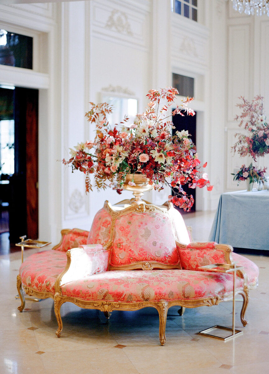 Wedding details: A coral flower centerpiece atop peach rental furniture at Kirby & Adam's Texas wedding