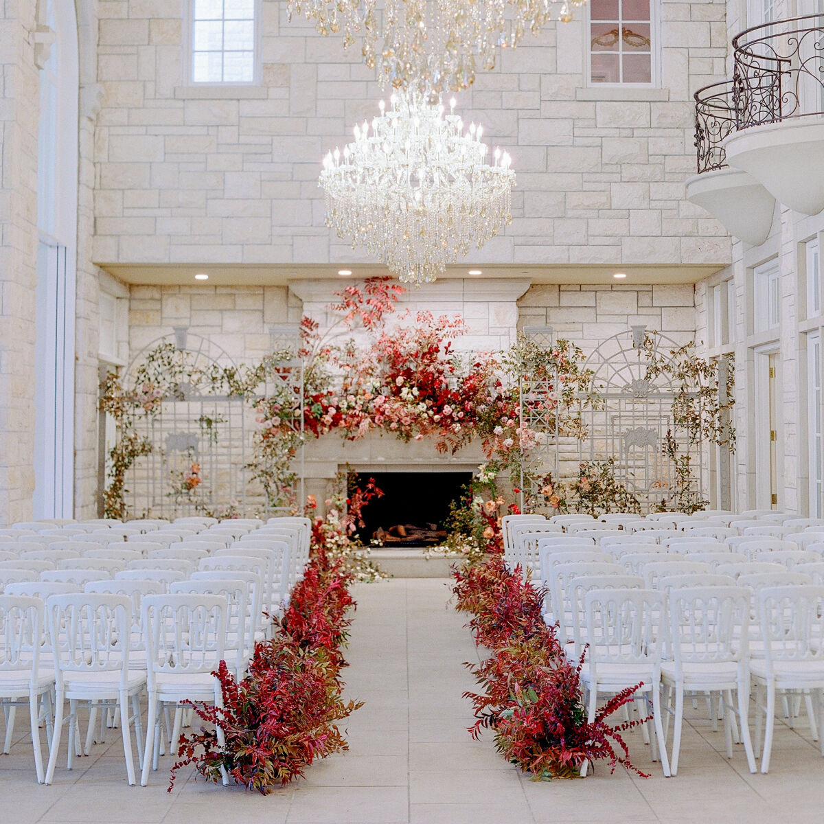 Wedding details: red and coral flowers line the aisle of Kirby & Adam's Texas wedding ceremony