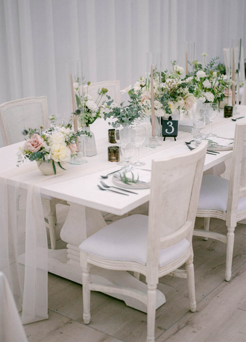 Wedding details: Upholstered chairs and gauzy table runners softened this reception table set-up.